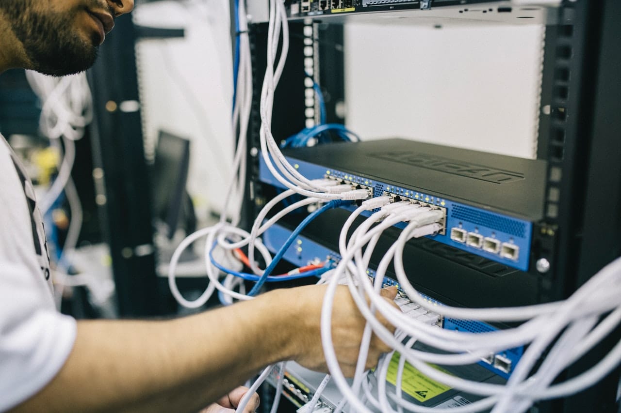 A tech employee troubleshoots computer hardware. 